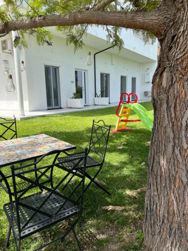 a table and chairs in a yard next to a tree at Appartamento Da Maria in Caulonia Marina