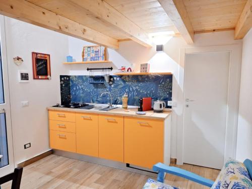 a kitchen with orange cabinets and a blue wall at Casa Azzurra - Casa dell'Ulivo in Triscina