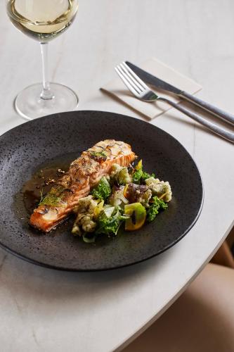 a black plate with a piece of food on a table at Century City Hotel Urban Square in Cape Town