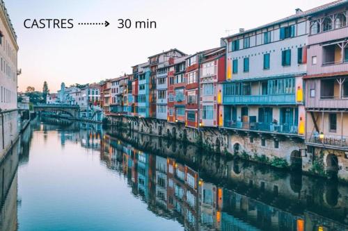 a group of buildings next to a river at T2 Cosy - 70m2 au Coeur de ville in Graulhet