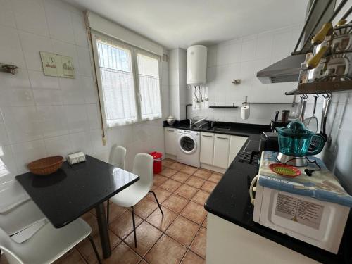 a kitchen with a counter and a table with chairs at Apartamento Marques de la Hermida in Santander