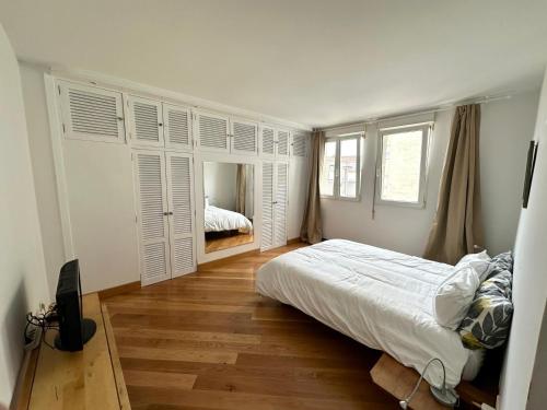 a white bedroom with a bed and a mirror at Apartamento Marques de la Hermida in Santander