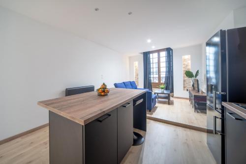 a kitchen with a island with a wooden counter top at MyAppart71 - La préfecture - Appartement en Coeur de Ville in Mâcon