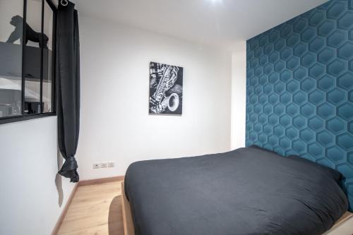 a bedroom with a bed with a blue headboard at MyAppart71 - La préfecture - Appartement en Coeur de Ville in Mâcon