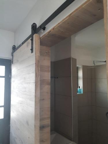 a bathroom with a shower with a wooden wall at Studio Apartment near the Airport in Nairobi