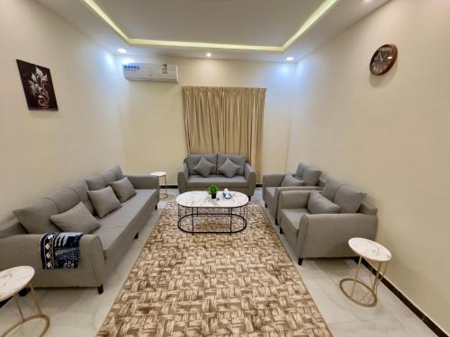 a living room with couches and a table at Tamyoz Aqama for Serviced Apartments in Hail