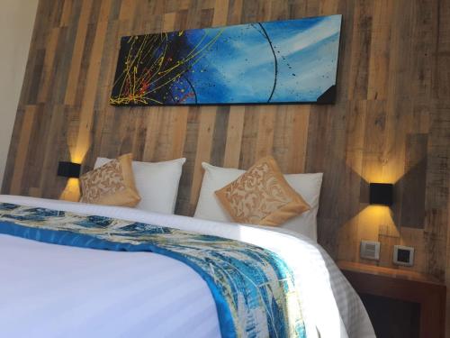 a bedroom with a bed and a painting on the wall at Studio Apartment near the Airport in Nairobi