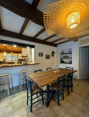 une salle à manger avec une grande table et des chaises en bois dans l'établissement Villa Les Oliviers, aux Angles (Gard)