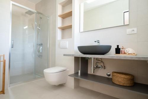 a bathroom with a sink and a toilet and a shower at Villa Thora in Podorljak