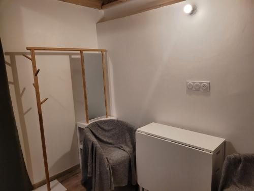 une salle de bain avec un miroir et une serviette sur une chaise dans l'établissement studette chez l'habitant, à Saint Lo