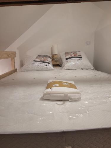 - un lit blanc avec un téléphone dans l'établissement studette chez l'habitant, à Saint Lo