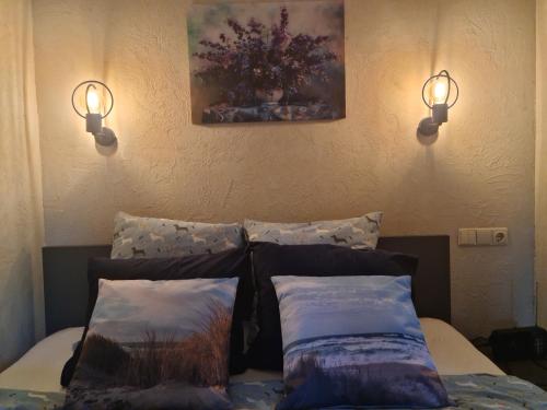a bedroom with two pillows on a bed with two lights at Vila Šventoji in Šventoji