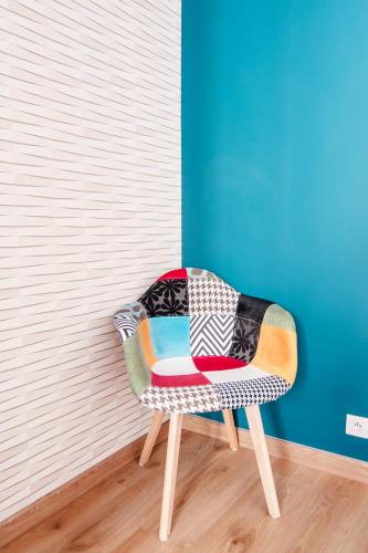 a colorful chair in a room with a wall at MyAppart71 - La préfecture - Appartement en Coeur de Ville in Mâcon
