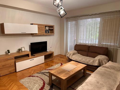 a living room with a couch and a tv at Dada Lux in Kumanovo