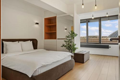 Un dormitorio con una cama grande y una ventana grande. en RH Apartment - Opposite Bucharest Mall, Metro, Balcony - RH Living, en Bucarest