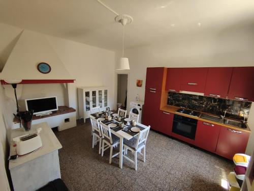 a kitchen with red cabinets and a table and chairs at Populonia corso apartment in Populonia