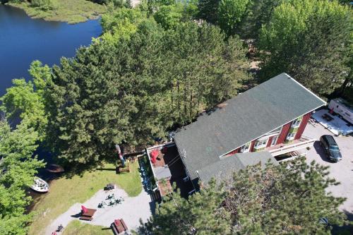 an overhead view of a house with trees and a lake at Auberge de Ferme-Neuve in Ferme-Neuve