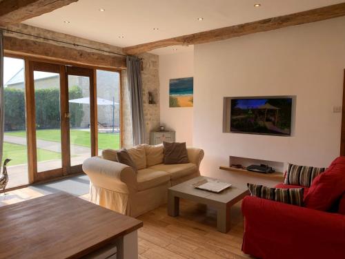 un salon avec un canapé et une table dans l'établissement Le Pressoir de la Vieville, Gite Moliere, à Mandeville-en-Bessin