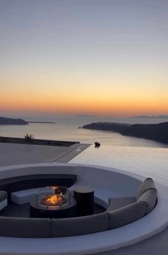 a fire pit on the roof of a house with a sunset at Caldera's Memories in Imerovigli