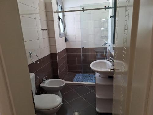 a bathroom with a toilet and a sink at Vacanze Pushime Albania in Radhimë