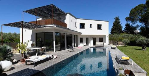 une maison avec une piscine devant une maison dans l'établissement Magnifique contemporaine avec couloir de nage 15X3,5, à Sommières