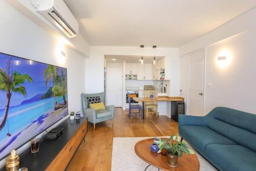 a living room with a blue couch and a table at Mandarin Hotel 1BD Beach Flat in Jlil