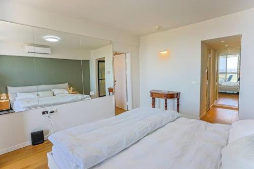 a large bedroom with two beds and a mirror at Mandarin Hotel 1BD Beach Flat in Jlil