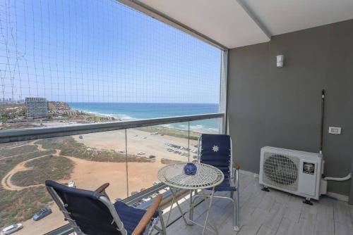 a balcony with a table and chairs and a view of the ocean at Mandarin Hotel 1BD Beach Flat in Jlil
