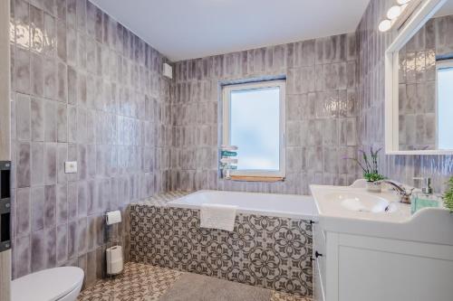 a bathroom with a tub and a sink and a toilet at Szabadi Pihenőház by BLTN in Siófok