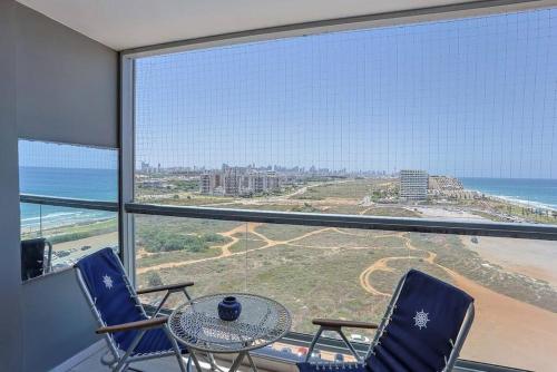 a room with a table and chairs and a view of the ocean at Mandarin Hotel 1BD Beach Flat in Jlil
