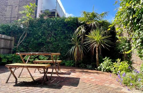 a picnic table and a bench in a garden at Little Chelsea Garden Flat in Eastbourne