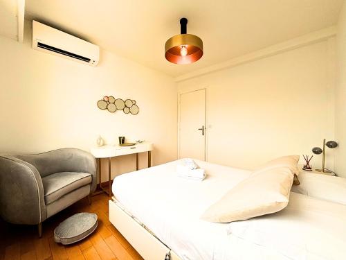 une chambre avec un lit et une chaise dans l'établissement Le St Charles, à Saint-Laurent-du-Var