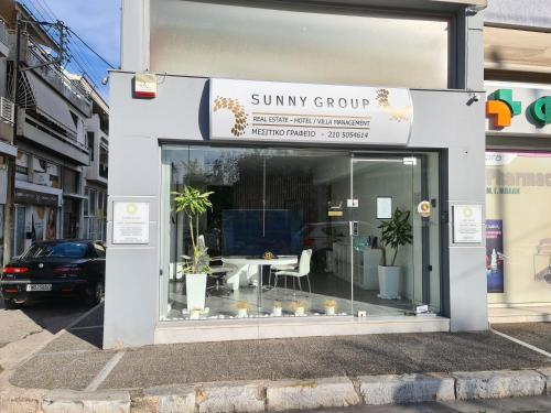 a suny group shop with a table in the window at Sunny Home Private Jacuzzi Hydromassage, Fireplace, Acropolis & Lycabettus View, Underground Parking, 300m Metro Peristeri in Athens