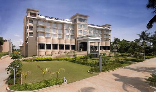 a large building with a lawn in front of it at Royal Orchid Central Kireeti Hampi, Hospet in Hampi
