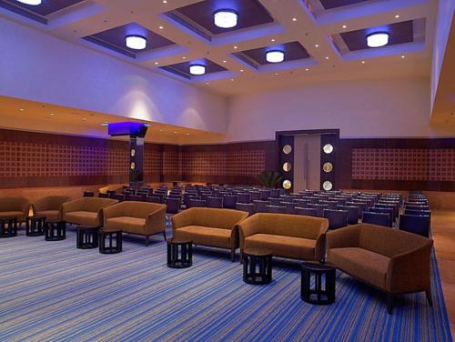 a large room with chairs and a stage in it at Royal Orchid Central Kireeti Hampi, Hospet in Hampi