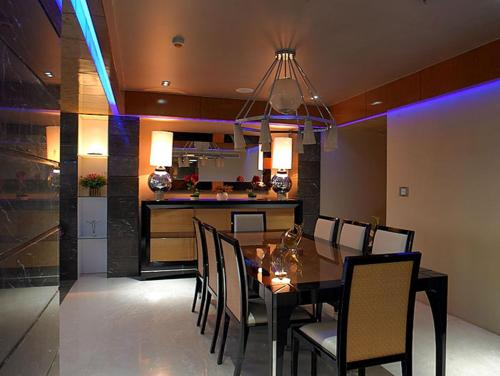 a dining room and kitchen with a table and chairs at Royal Orchid Central Kireeti Hampi, Hospet in Hampi