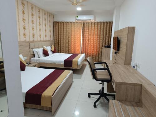 a bedroom with two beds and a desk and a chair at Hotel Seth Murlidhar Seva Sadan-Near Prem Mandir in Vrindāvan