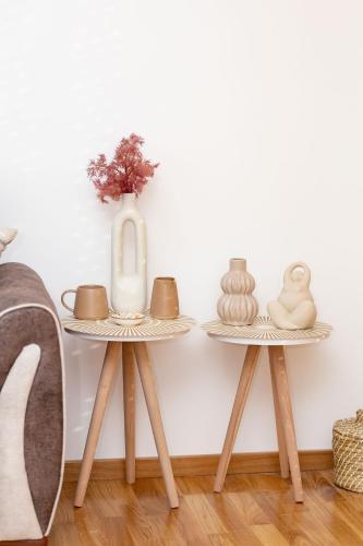 two tables with vases and a vase on them at Elegant Escape Podgorica in Podgorica