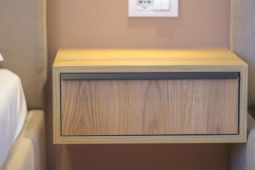 a wooden bedside table with a drawer in a bedroom at Emily’s Hotel in Himare