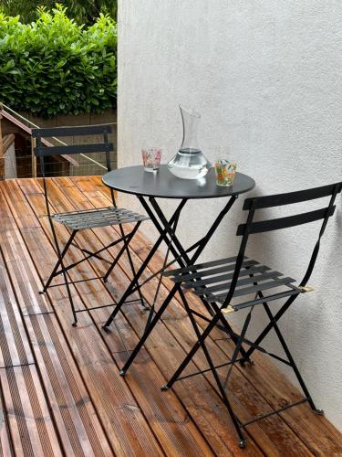 - une table noire et deux chaises sur du parquet dans l'établissement La Maison du Bonheur, à Saint-Herblain
