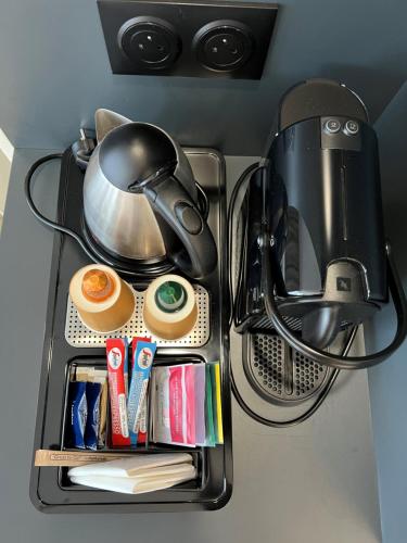 a tray with a tea pot and other utensils at Mercure Saint Lô Centre in Saint Lo