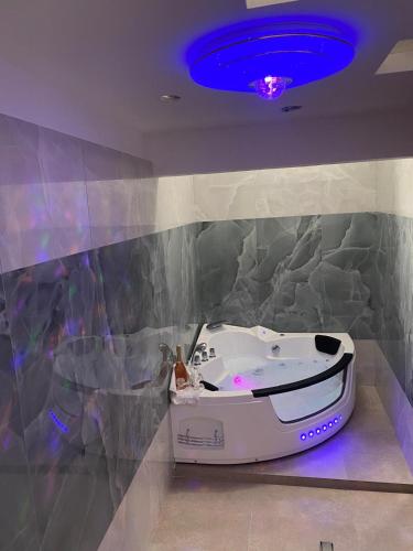 a bath tub in a bathroom with a purple ceiling at TRULLO AURORA BOREALE in Alberobello