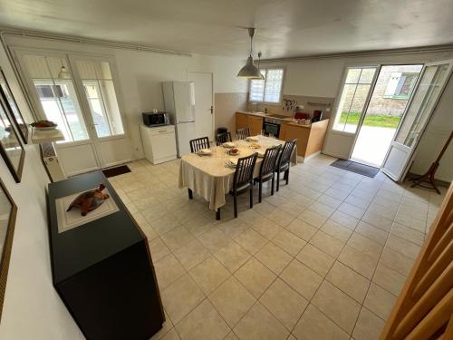 une cuisine et une salle à manger avec une table et des chaises dans l'établissement Écurie des Charmes à 5 minutes de la plage, à Merville-Franceville-Plage