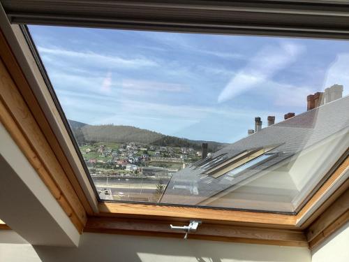 a window in a house with a view of a city at Rego de Flores in Viveiro