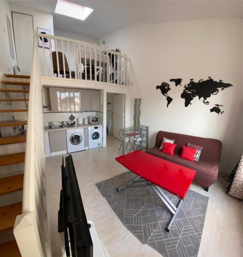 - un salon avec un canapé et une table rouge dans l'établissement La Rochelle - Tout confort pour 4 personnes proche vieux port, à La Rochelle