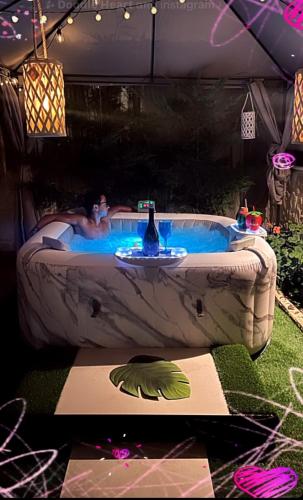 a person in a hot tub in a backyard at Heraklia villa sea view pool & jacuzzi in Nea Iraklia