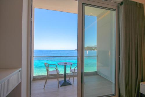 a room with a view of the ocean and a table at Emily’s Hotel in Himare