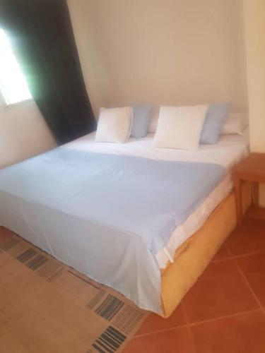 a large white bed with two pillows on it at Poco Loco B&B in Abene