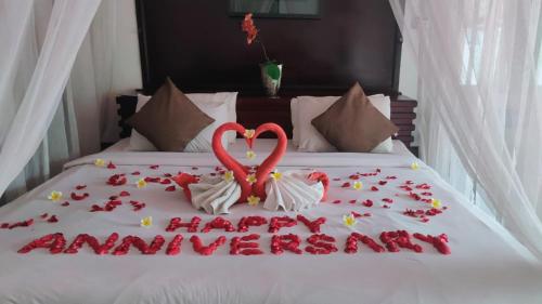 a cake on a bed with hearts and flowers at One Bedroom Private Pool Classic Villa in Kuta