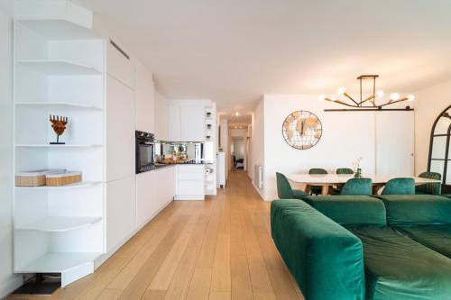a living room with a green couch and a table at Sunny Days in Nice